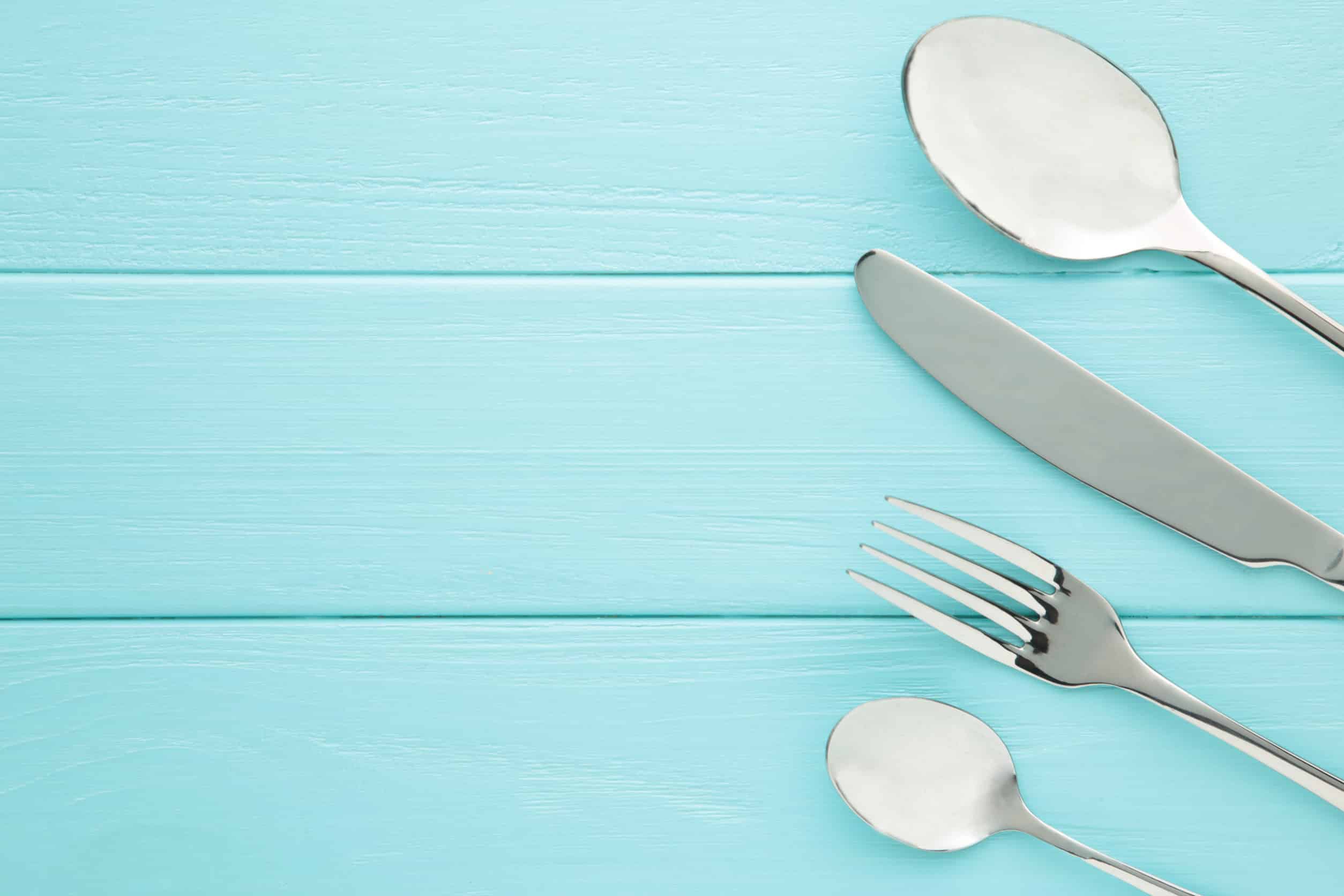Comment bien acheter sa ménagère ? table setting with cutlery fork, spoon and knife. shot from above. top view